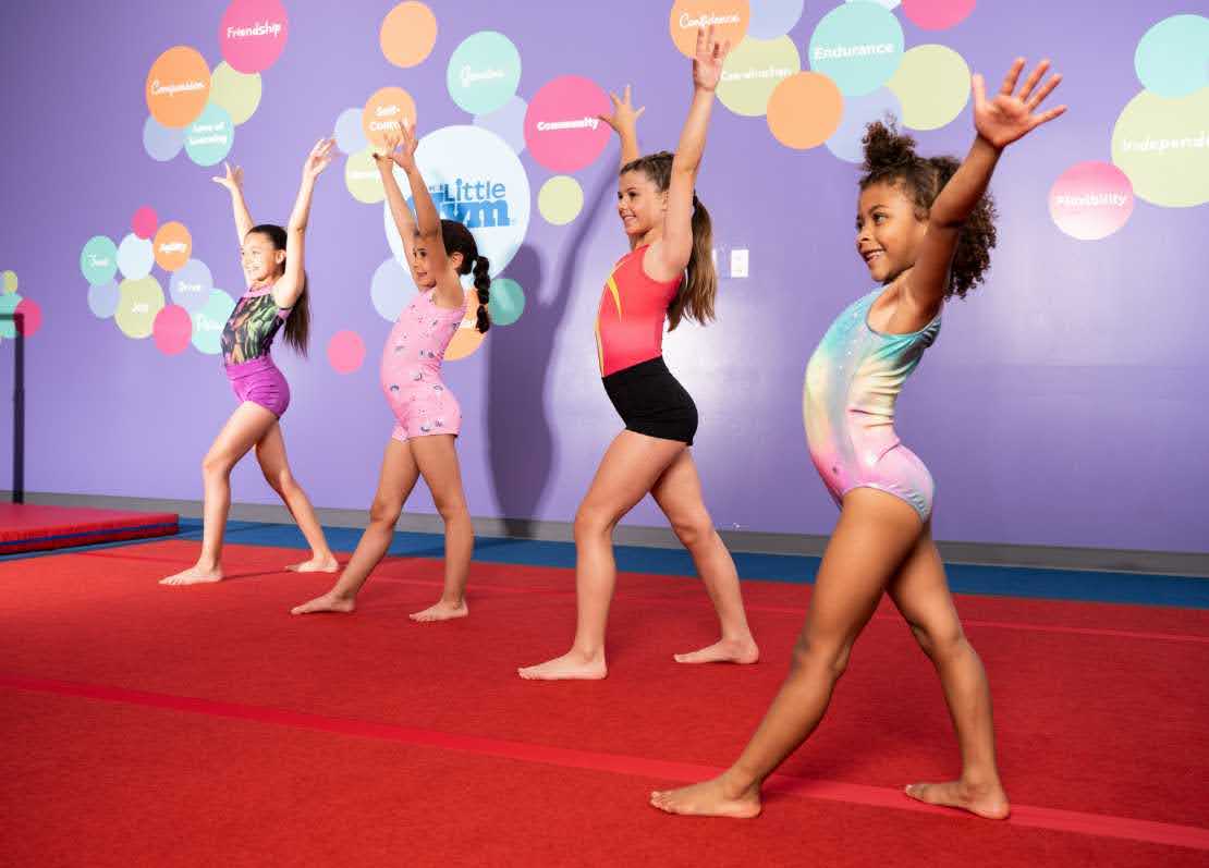 young girl doing an assisted handstand