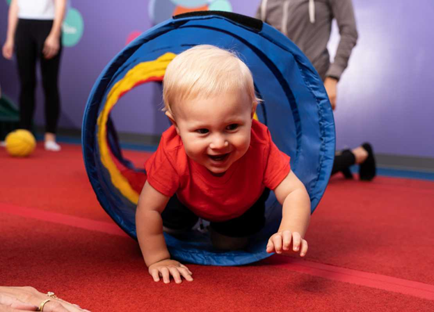 baby crawling through a soft tunnel