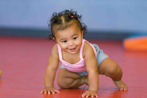 infant girl learning to crawl