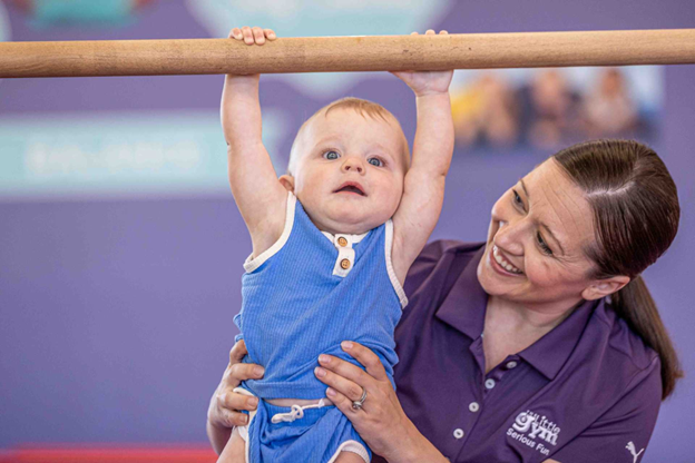 an infant with an instructor at the little gym