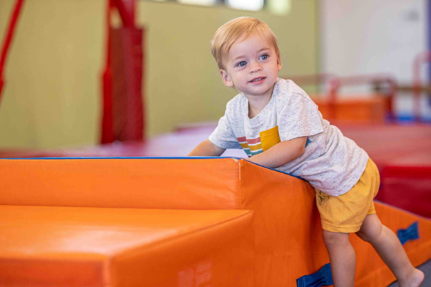 A child climbing on an orange block