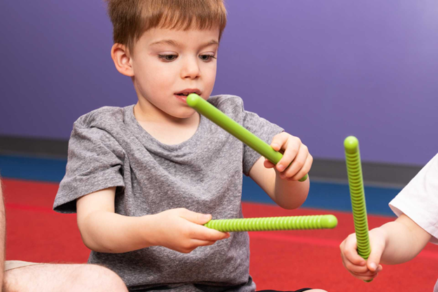 toddler boy playing with rythm stick