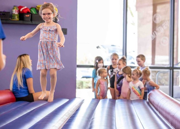  A child jumping on an AirMat at the Little Gym